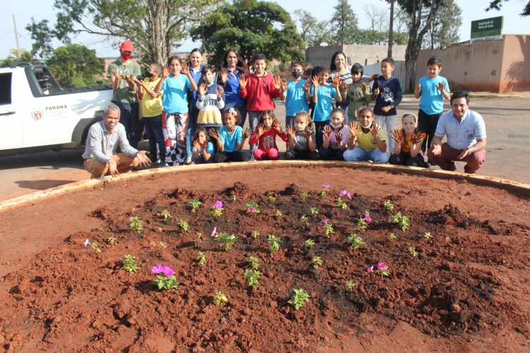 Alunos e professores da Escola Municipal Manoel Ribas realizaram plantio de flores e de grama em rotatória 